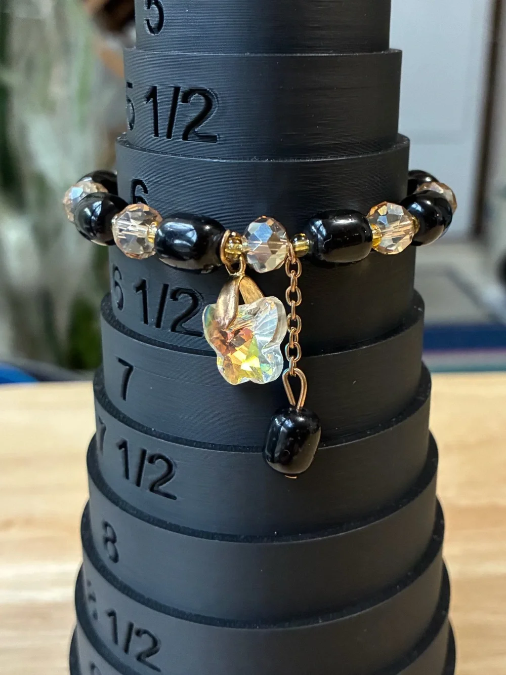 Black and Gold Beaded Stretch Bracelet with Iridescent Flower Charm - Picture 1 of 9